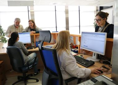 Profesionales sanitarios atendiendo usuarios en el centro de salud Los Bermejales, en Sevilla