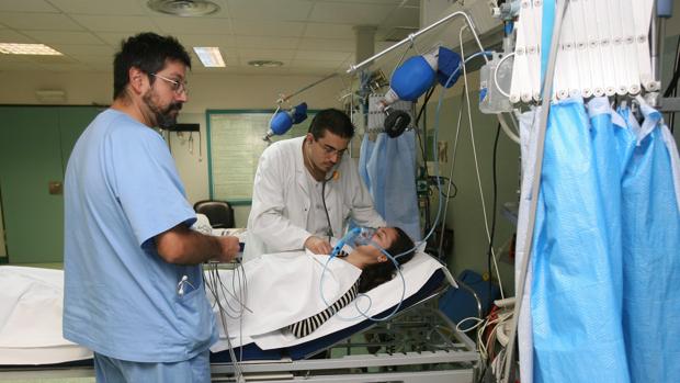 Un doctor y un enfermero atienden a una paciente en el hospital Reina Sofía de Córdoba
