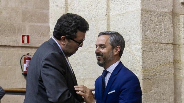 El consejero de Hacienda, Juan Bravo, dialoga con el presidente de Vox, Francisco Serrano en el pleno de este jueves
