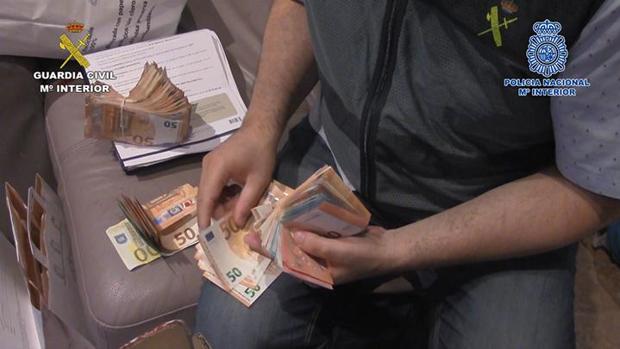 Un agente de la Guardia Civil cuenta dinero requisado al grupo criminal