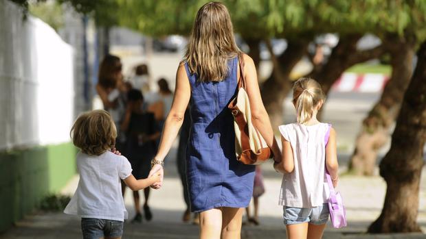 Una madre acompaña a sus hijos al colegio