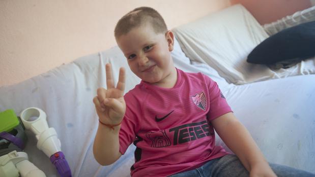 Cristian en su casa con la camiseta que le han regalado los jugadores del Málaga C. F.