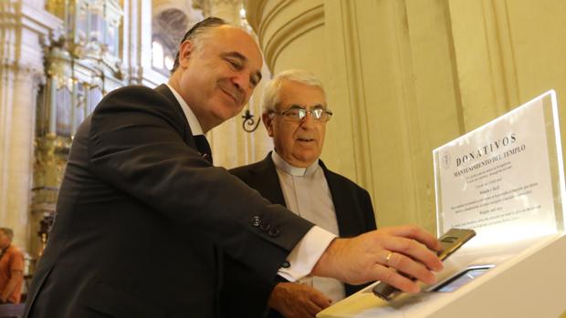 El director territorial de CaixaBank en Andalucía Oriental y Murcia, Juan Ignacio Zafra, y el deán de la Catedral, Antonio Aguilera, prueban uno de los cepillos
