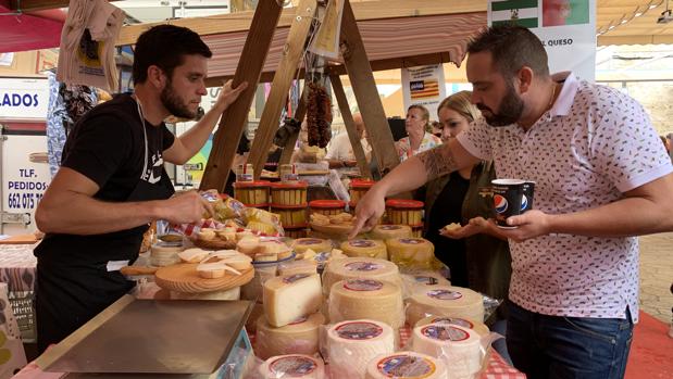 Un quesero atiende a uno de los visitantes de la Fiesta del Queso