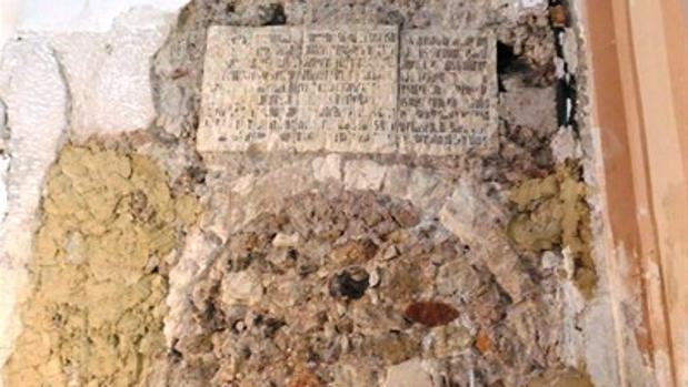 Las tres losas con la inscripción y el arco hallados empotrados en un muro de la iglesia de San Nicolás de Bari
