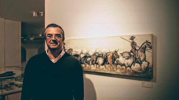 El ganadero y pintor Joaquín Lora junto a una de sus obras -