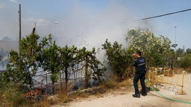 Un policía local de Coria apaga un fuego con la manguera de un particular ante la ausencia de los bomberos