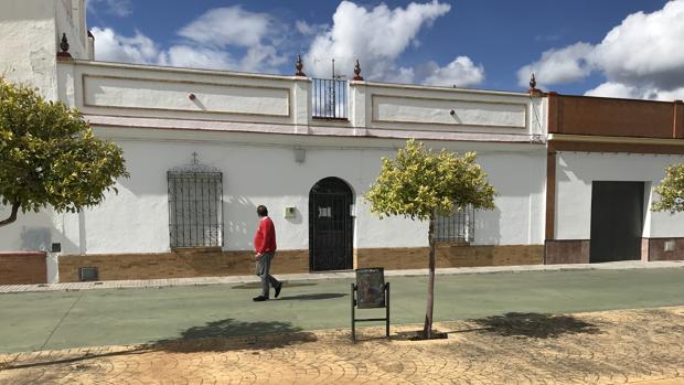 Un vecino pasea por delante de la vivienda donde fue hallada muerta Floriana, en Aznalcóllar