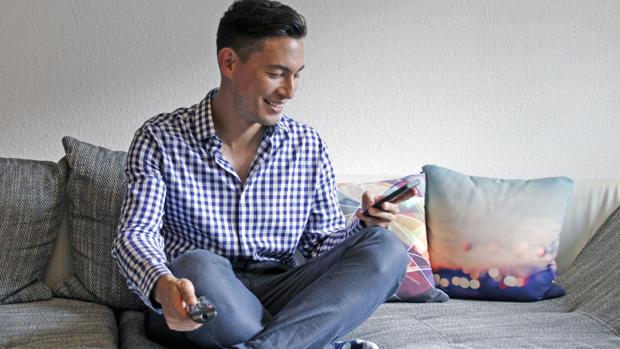 Un joven usando el teléfono móvil como entretenimiento