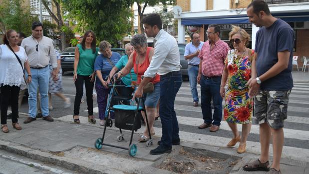 Beltrán Pérez ayuda a una mujer a caminar con su andador